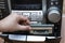 Man hand putting cassette into old fashioned audio tape player on desk wood background