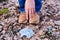 A man hand reaches for a dirty discarded medical mask on the ground