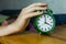 Man hand reaching alarm clock in the morning