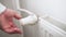 Man hand regulates temperature knob of heating radiator for heating room