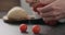 Man hand remove cherry tomatoes from branch on conrete countertop