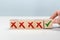Man Hand selects checkbox with green checkmark from row of multiple boxes with red crosses. Right or Wrong. Concept of positive or