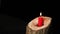 Man hand set on fire on candle in wooden candlestick black background