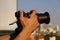 Man hand shooting a video with a building and city view