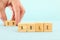 man hand spelling the text unable with wooden cubes, taking out the word un so it written able. success and challenge concept.