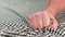 Man hand squeezing of checkered fabric close up. The hand clenches into a fist then unclenches and disappears from the