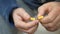 Man hand take pills from blister pack. Close up of male hand pour white orange round tablet. Medicament dose pill in hand. Flu sic