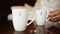man hand takes mug with inscription you and me. Bride and groom drinking coffee