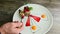 Man hand takes part of sliced mousse raspberry dessert by fork