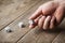 Man hand throwing white dice on wooden table. Gambling devices. Game of chance concept.