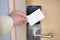 Man hand use key card switch in to open hotel room door