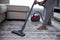 Man hand vacuuming carpet
