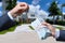 Man Handing a man Thousands of Dollars For Keys in Front of House.