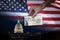 Man handing Stimulus check to people with the US Capitol and flag on the Background.