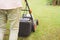 Man handling  green lawn with lawnmower