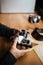 Man hands adjusts the lens retro camera on a wooden table