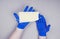 Man hands in blue disposal gloves hold disposal medicine face mask