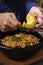 Man hands breaking avocado into traditional Colombian dish. Hand serving avocado on traditional stew dish in Latin America