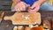 Man hands carefully cleaning wild mushroom with kitchen knife. Hands take mushroom and remove clay or roots from stem