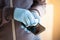 Man hands in gloves disinfecting smartphone, eliminating germs coronavirus bacteria