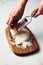 Man hands grating parmesan cheese on a wooden board. White, bright and clean background.