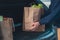 man hands with groceries bags put it in car trunk