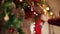 Man hands hanging Christmas stocking or sock above fireplace decorated with colorful flashing garland lights and wreath