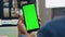Man hands hold chromakey mobile phone in office closeup. Designer using device