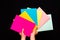 Man hands holding blank pride colored papers sheet A3 size on black background