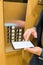 Man hands holding blank screen mobile phone next to elevator control panel