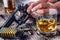 Man hands holding gun and alcohol glass on the table