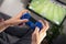 Man hands holding joystick and playing video game at home on coach sofa in front of television with play game console