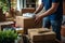 Man hands packing boxes on a moving day. A guy packing household items into carton boxes in a living room or kitchen to move to a