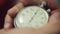 Man hands push button of old round stopwatch. Close up