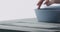 Man hands sand bottom of blue ceramic bowl