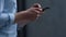 Man hands swiping smartphone with finger close up. Manager working outdoors.