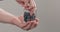 Man hands take wet washed ripe blueberries from glass jar on neutral background