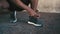 Man, hands and tie shoes for running, fitness or workout exercise on outdoor concrete floor. Closeup of African male