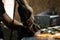 Man hands treating metal parts of hardware in a workshop with an