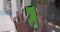 Man hands using smartphone with mock up screen. Close up view of afro american guy touching and zooming phone green