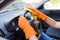 Man hands wearing rubber gloves and polishing steering wheel with microfiber cloth