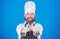 Man handsome with beard holds kitchenware on blue background. Cooking process concept. Lets try dish. Hungry chef ready