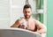 Man handsome muscular guy relaxing in bath. Skin care concept. Taking bath with soap suds. Treating yourself with a hot