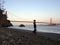 Man Handstands on beach in front of the Golden Gate Bridge