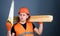 Man, handyman in helmet, hard hat holds handsaw, looks at sharp blade, grey background. Carpenter concept. Carpenter