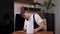 A man handyman repairs a broken electric kettle while sitting at a table.