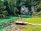 Man happily jumping on wooden planks on the side of a beautiful river