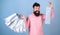 Man with happy face and trendy beard holding shopping bags. Shopaholic spending all salary on clothes. Bearded man in