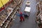 Man in hardhat working with pallet truck at warehouse, above view. Logistics center