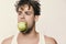 Man has an apple. Guy with busy face isolated on light grey background